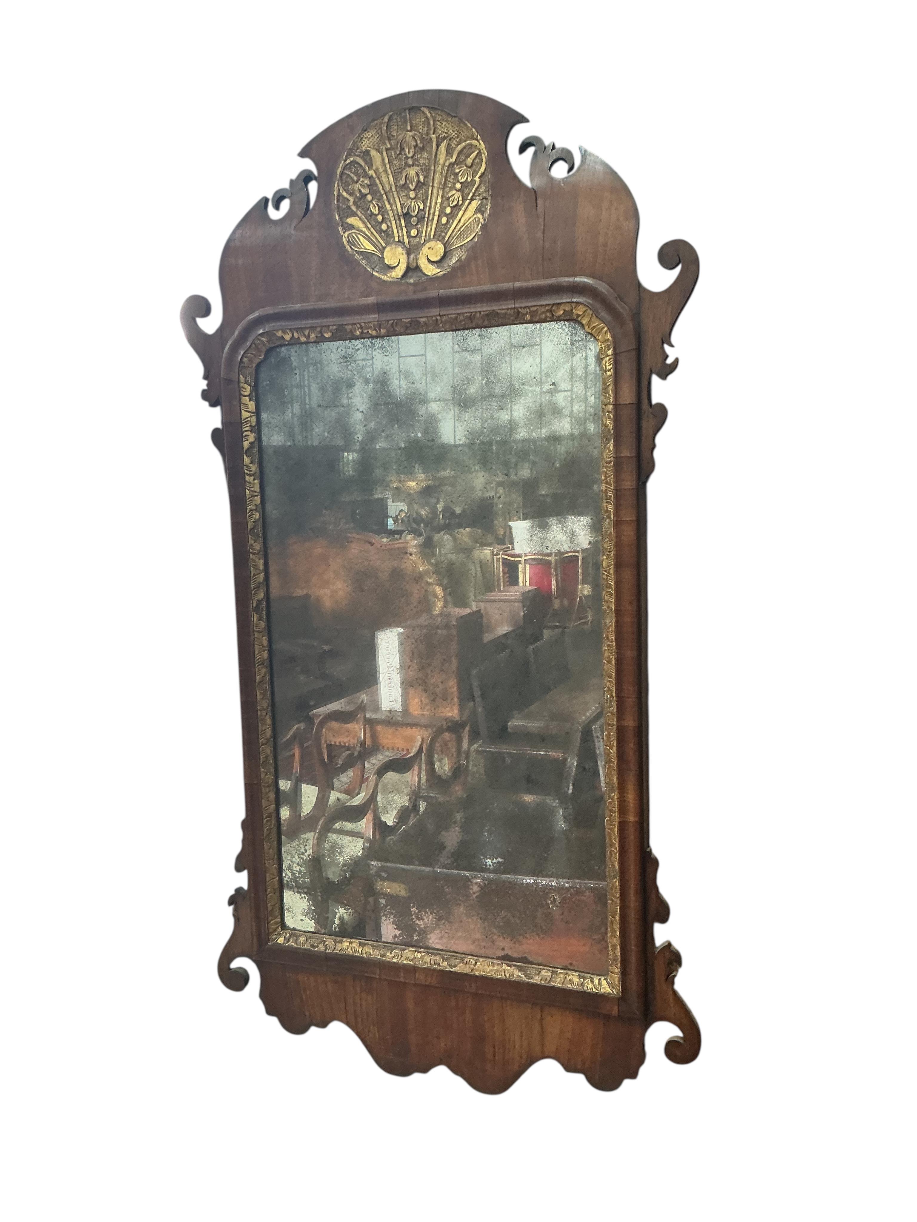 A walnut and parcel gilt fret cut mirror, width 46cm, height 86cm